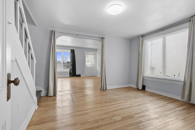 unfurnished room with a textured ceiling and light wood-type flooring