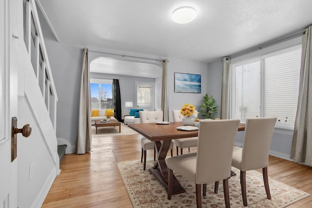 dining room featuring a textured ceiling, light hardwood / wood-style flooring, and a healthy amount of sunlight