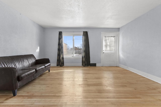 living room featuring a textured ceiling and light hardwood / wood-style floors