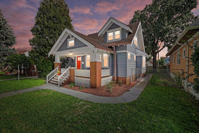 view of front of house with a porch and a lawn