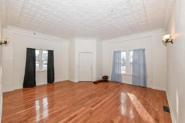 unfurnished room featuring wood-type flooring and ornamental molding