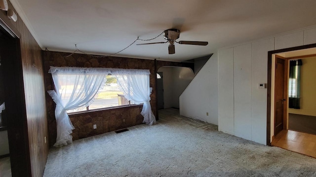 unfurnished room featuring crown molding, light carpet, and ceiling fan