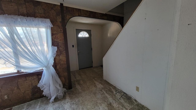 carpeted foyer featuring ornamental molding