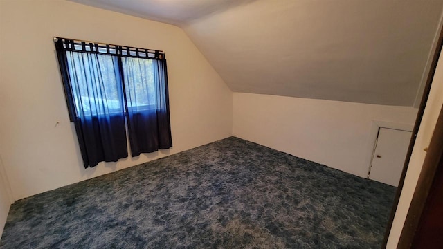 bonus room featuring lofted ceiling and dark carpet