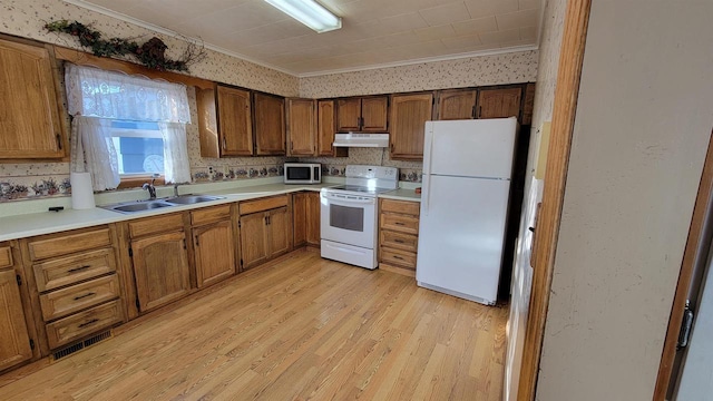 kitchen featuring ornamental molding, sink, white appliances, and light hardwood / wood-style floors