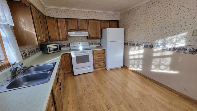 kitchen featuring crown molding, sink, white appliances, and light hardwood / wood-style flooring