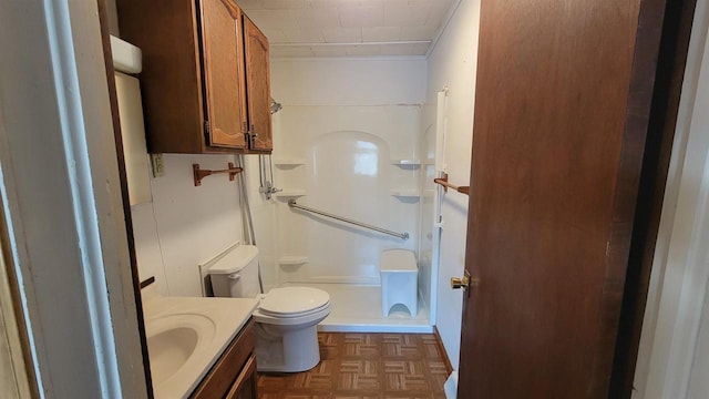 bathroom featuring parquet floors, vanity, and toilet