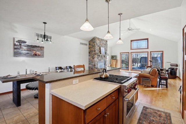 2743 Brooks Ridge Dr, Sun Prairie, WI 53590 - kitchen with light tile patterned flooring, lofted ceiling, high end stainless steel range, hanging light fixtures, and ceiling fan