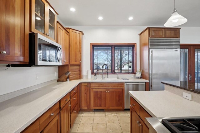 2743 Brooks Ridge Dr, Sun Prairie, WI 53590 - kitchen with stainless steel appliances, hanging light fixtures, sink, and light tile patterned floors