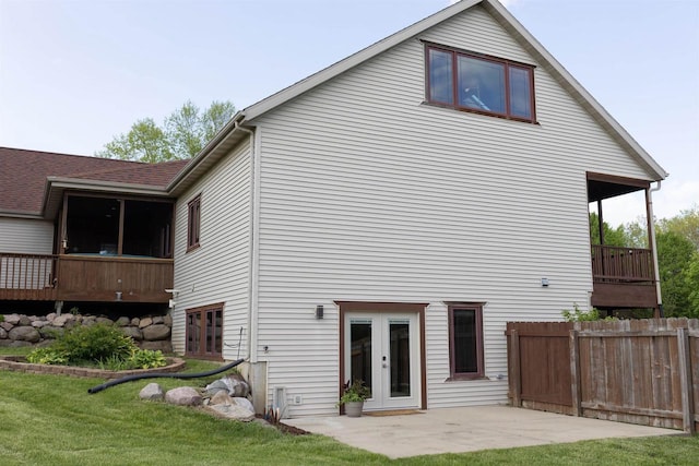 rear view of property with french doors, a patio area, and a lawn