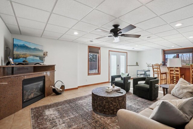 2743 Brooks Ridge Dr, Sun Prairie, WI 53590 - tiled living room featuring ceiling fan, a drop ceiling, a high end fireplace, and french doors
