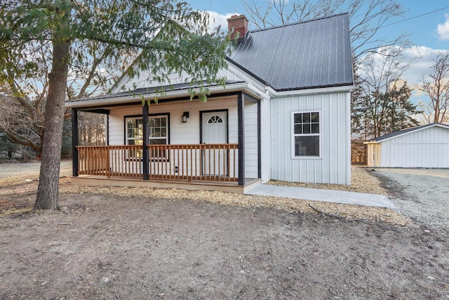 view of front of home with a porch and a storage unit