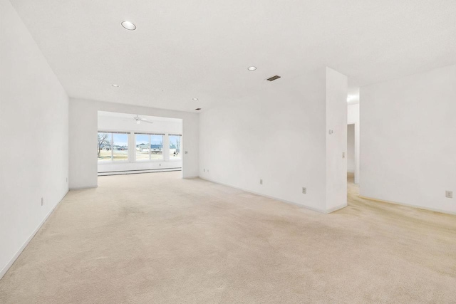 empty room featuring recessed lighting, light carpet, visible vents, and baseboard heating