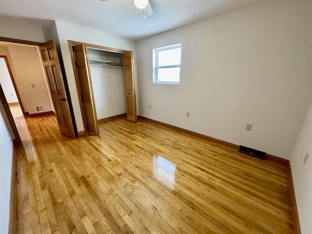 unfurnished bedroom with ceiling fan, light hardwood / wood-style floors, and a closet