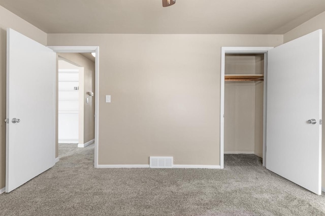 unfurnished bedroom featuring light carpet and a closet