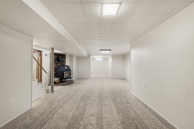 basement with carpet floors and a wood stove