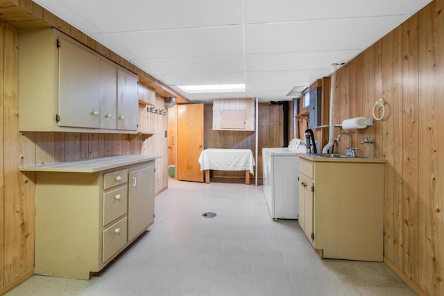 washroom featuring cabinets, sink, and wooden walls