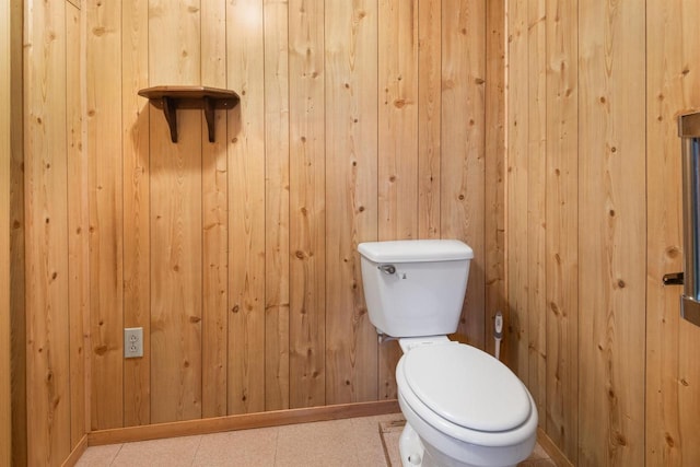 bathroom with wooden walls and toilet