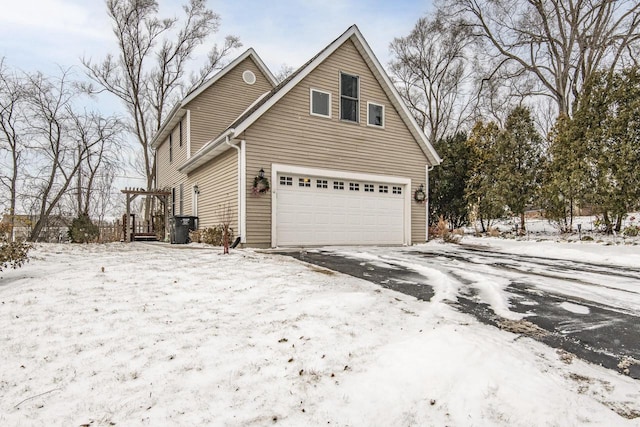 snow covered property with a garage