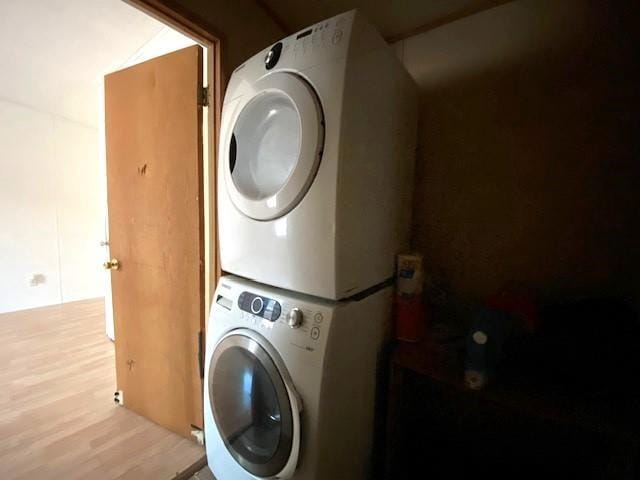 laundry area with stacked washer / dryer and light hardwood / wood-style floors