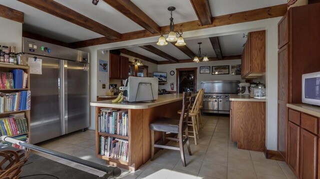 N3684 Claire Rd, Taylor, WI 54659 - kitchen featuring light tile patterned flooring, pendant lighting, beamed ceiling, a kitchen bar, and built in refrigerator