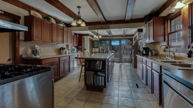 N3684 Claire Rd, Taylor, WI 54659 - kitchen with light tile patterned flooring, stainless steel gas range oven, decorative light fixtures, a center island, and beam ceiling