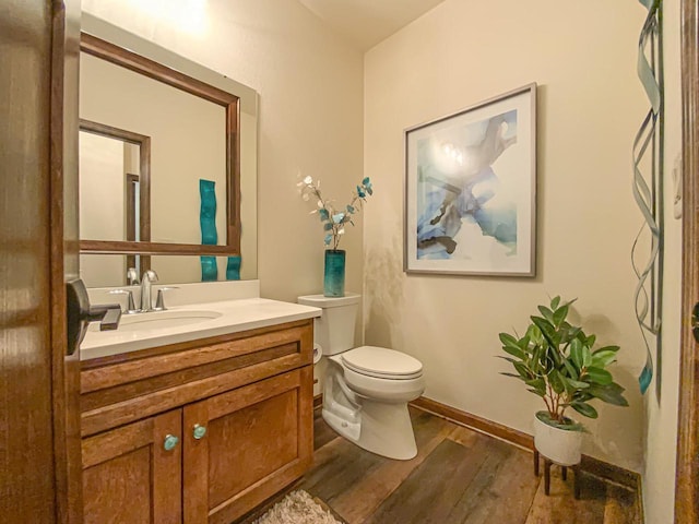 bathroom featuring wood-type flooring, vanity, and toilet