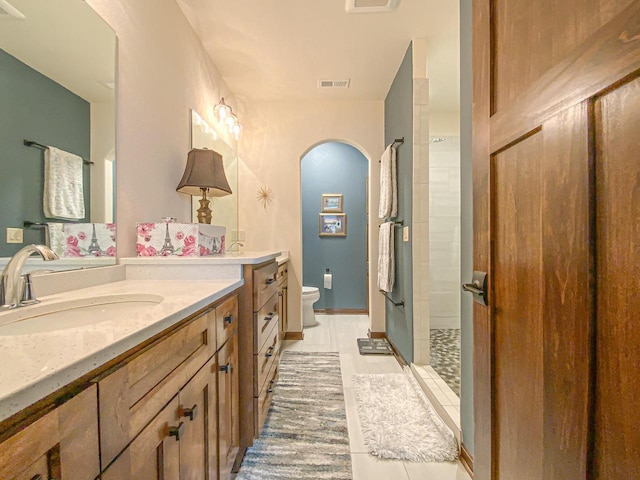 bathroom with toilet, vanity, and walk in shower