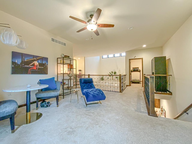 living area featuring carpet and ceiling fan