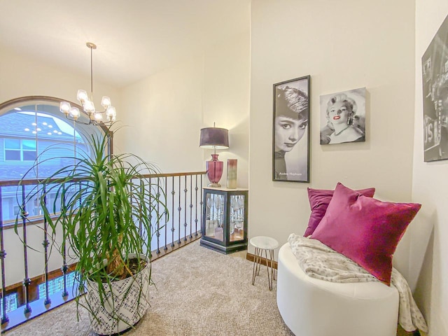 living area featuring carpet flooring and an inviting chandelier