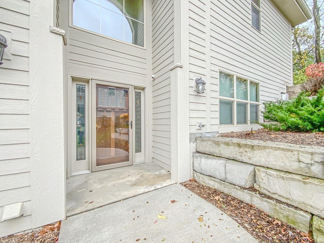 view of exterior entry with a patio area