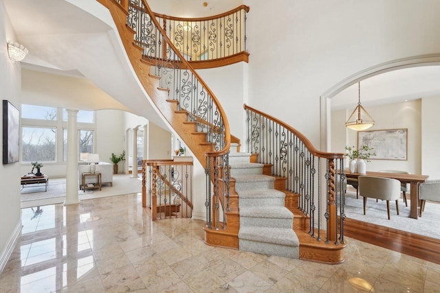 stairs with decorative columns and a high ceiling