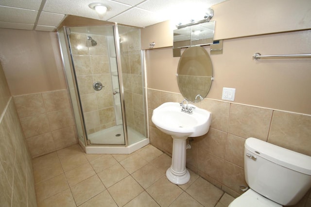 bathroom featuring tile walls, an enclosed shower, tile patterned floors, and toilet