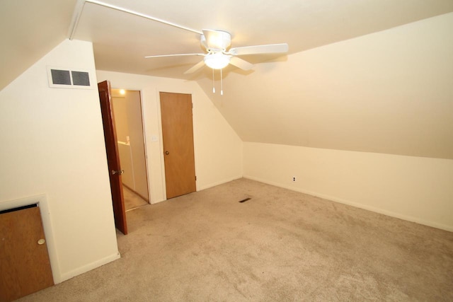 additional living space with ceiling fan, light colored carpet, and vaulted ceiling