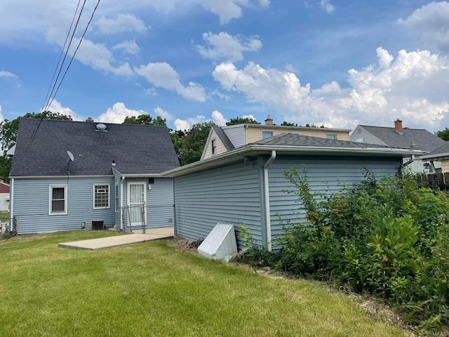 rear view of house with a patio and a lawn