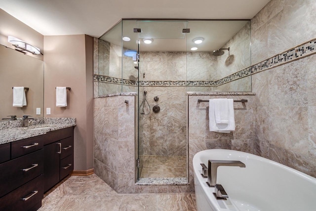 full bath featuring a stall shower, a bathtub, and vanity