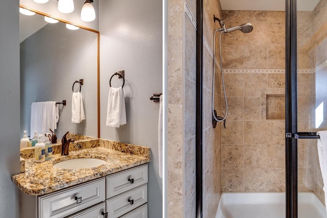 bathroom featuring tiled shower and vanity