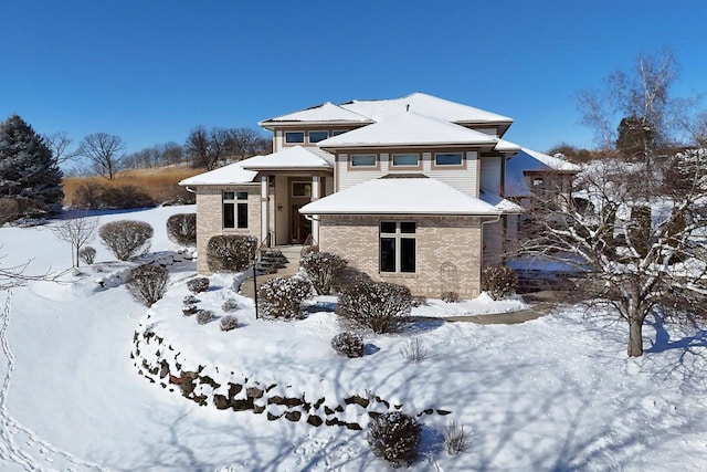 prairie-style home featuring brick siding