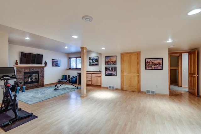 exercise room with visible vents, recessed lighting, light wood-style flooring, and ornate columns