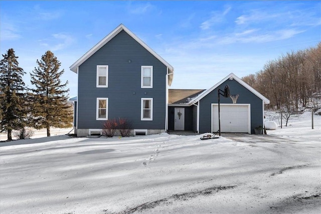 snow covered property featuring a garage