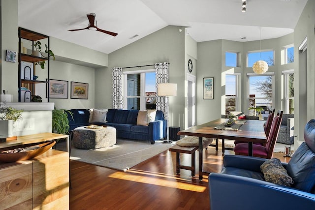 living room featuring hardwood / wood-style flooring, ceiling fan, and a high ceiling