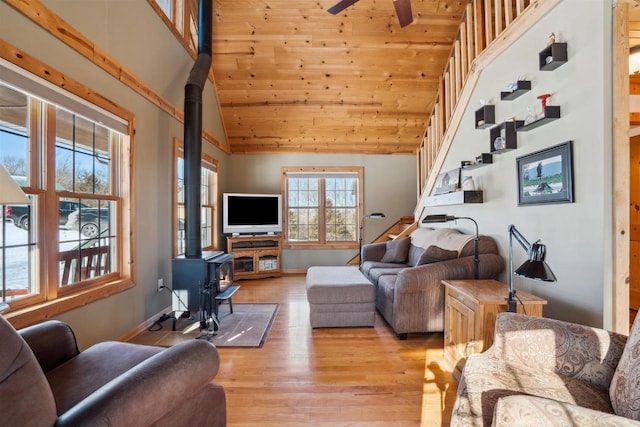 1726 Wynn Wood Ln, Harpers Ferry, IA 52146 - living area featuring a wood stove, stairway, light wood-style floors, high vaulted ceiling, and a ceiling fan