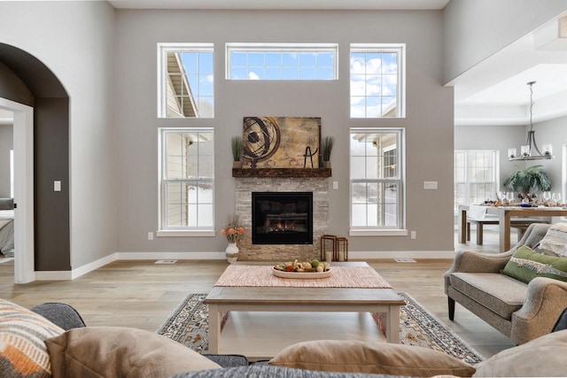 living room with a wealth of natural light, a fireplace, and light hardwood / wood-style floors