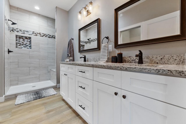 bathroom featuring vanity, hardwood / wood-style floors, and tiled shower