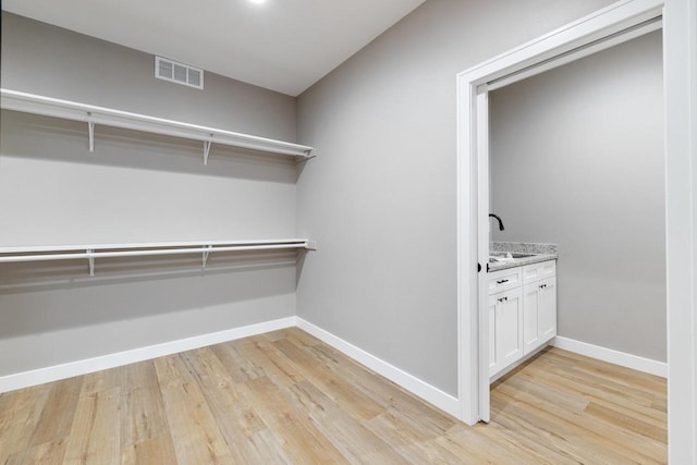 walk in closet featuring sink and light wood-type flooring