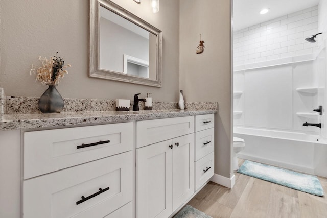 full bathroom featuring vanity, hardwood / wood-style flooring, tub / shower combination, and toilet