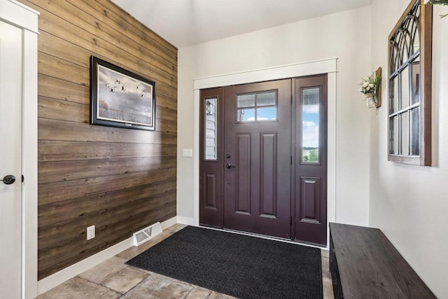 foyer entrance featuring wooden walls