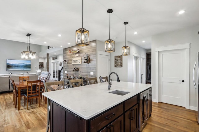 kitchen with pendant lighting, dark brown cabinetry, and sink