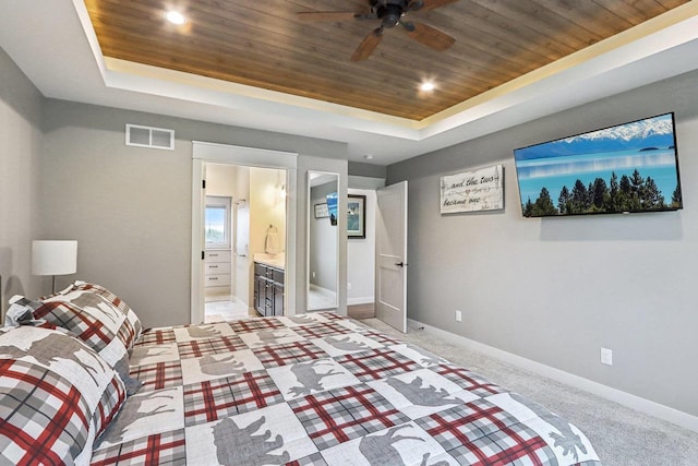 carpeted bedroom with ensuite bathroom, wooden ceiling, ceiling fan, and a tray ceiling