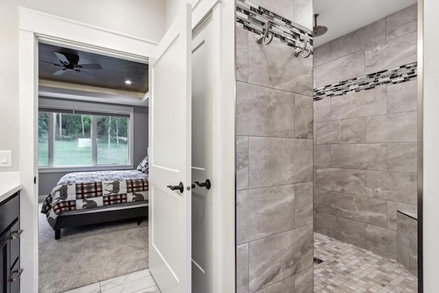 bathroom with vanity, tiled shower, and ceiling fan